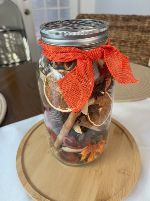 Completed aroma jar adorned with a colorful bow; grid cap visible.